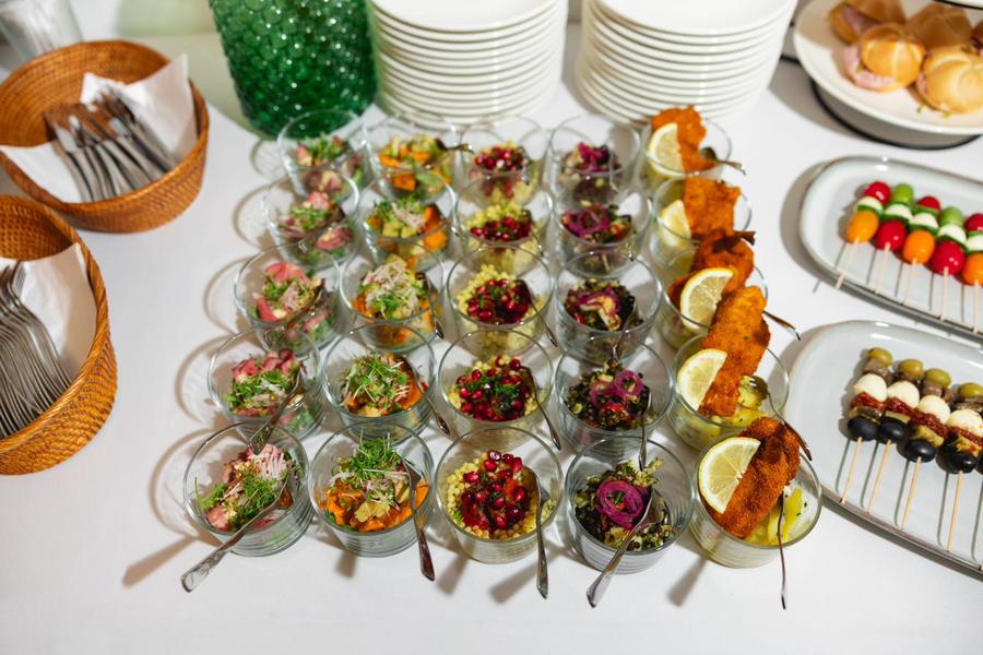 Kleine Gläser mit Vorspeisen, Obstspieße und Brotkörbe auf einem Buffet